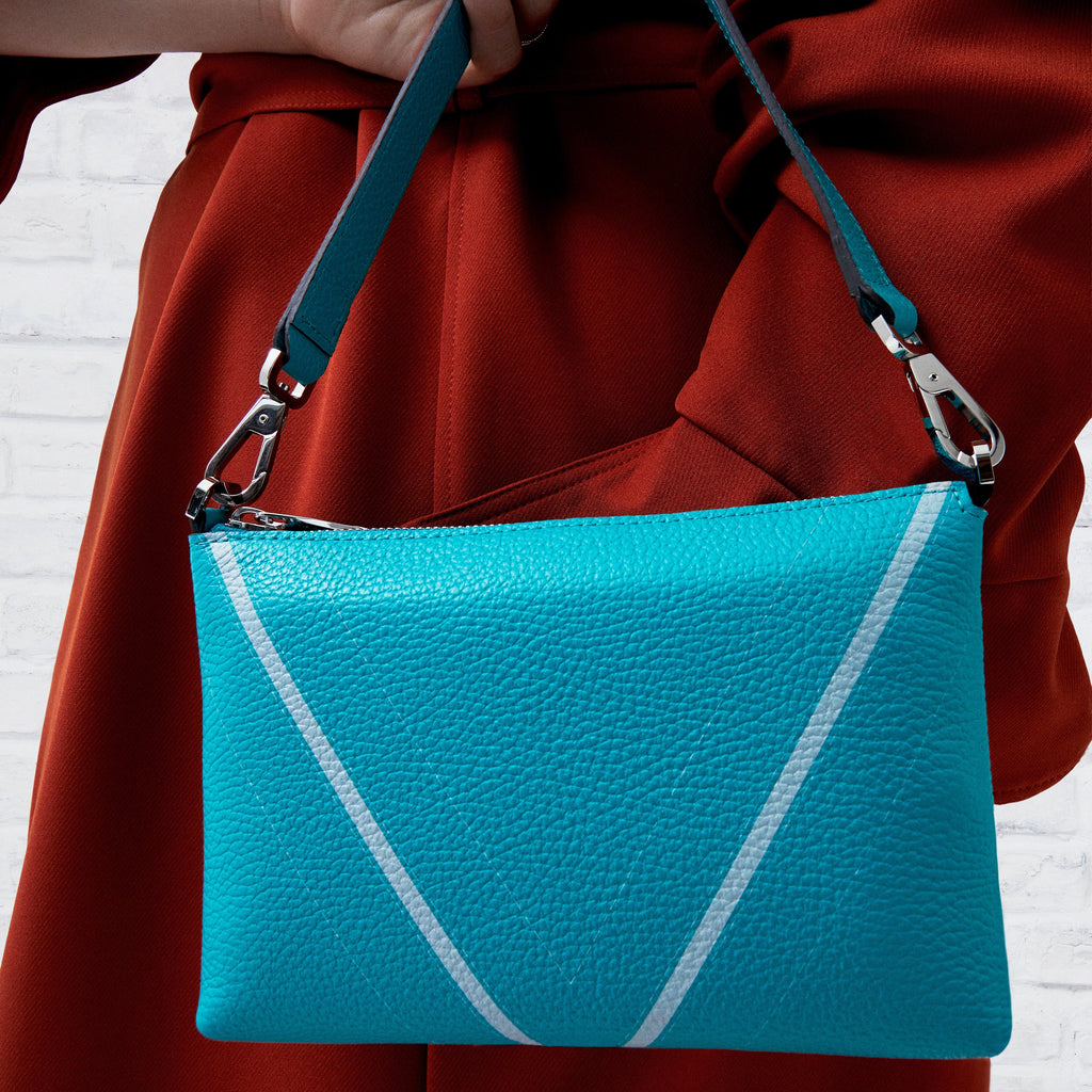 Model carrying The Arianna Monochrome Pouch in Emerald grained leather, expressing contemporary movement and understated Italian elegance.