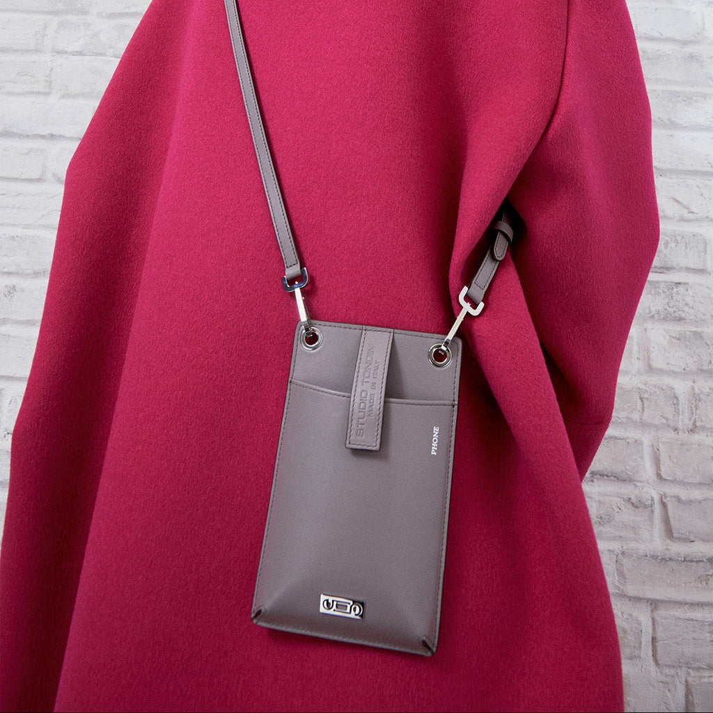 Editorial portrait of a model carrying The Come Fly with Me! in Light Grey leather, expressing contemporary movement, compact functionality, and understated Italian elegance.