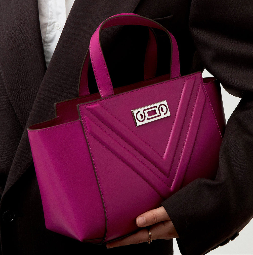The Maja Little Tote Bag worn by a model, showing compact proportions, structured elegance, and contemporary Italian craftsmanship in motion.
