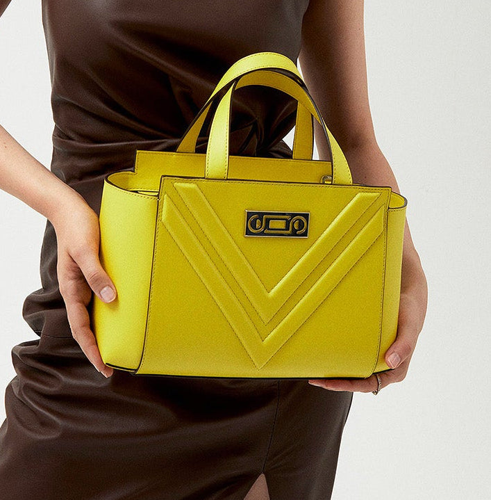 The Maja Little Tote Bag carried by a model, showing compact proportions and refined versatility designed for movement throughout the day.