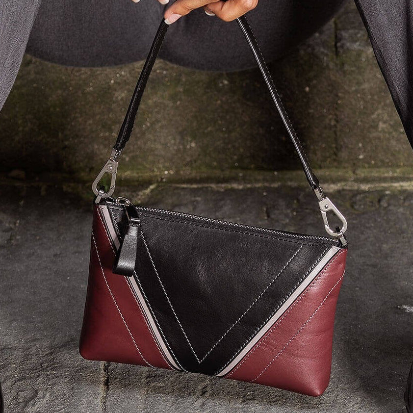 Model carrying The Arianna Pouch with Studio Tondini’s signature V-shape construction creating a black leather triangle, expressing understated elegance and cosmopolitan sophistication.