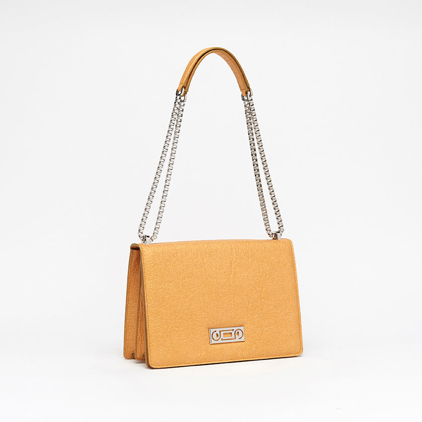 The Cristiana Vegan Shoulder Bag by Studio Tondini. Three-quarter view of the antique gold version, highlighting the radiant chain plated in real palladium and the sculptural structure crafted from Piñatex®.