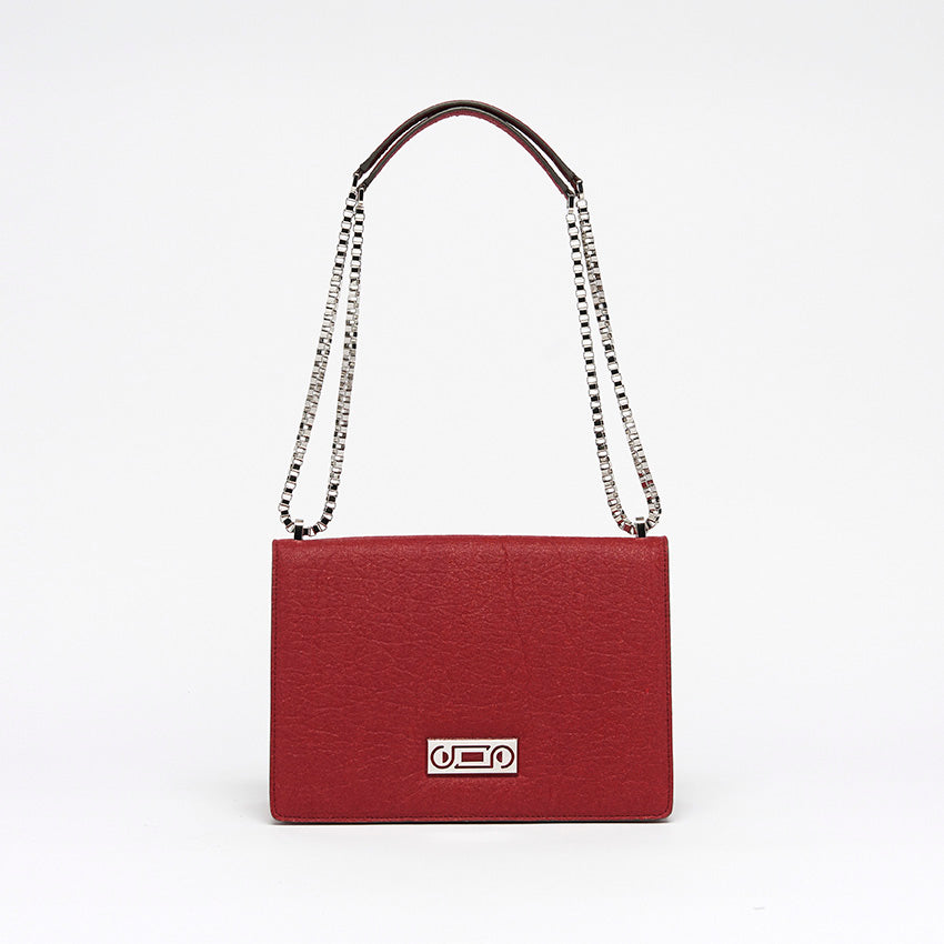 The Cristiana Vegan Shoulder Bag by Studio Tondini. Front view of the cherry red version with luminous palladium-plated hardware and a structured silhouette in Piñatex®. Ethical design meets timeless elegance.