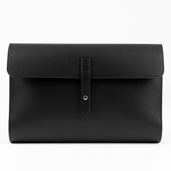 The Document Holder by Studio Tondini. Front view of black Italian leather bag with button closure, showcasing clean lines and fine craftsmanship.