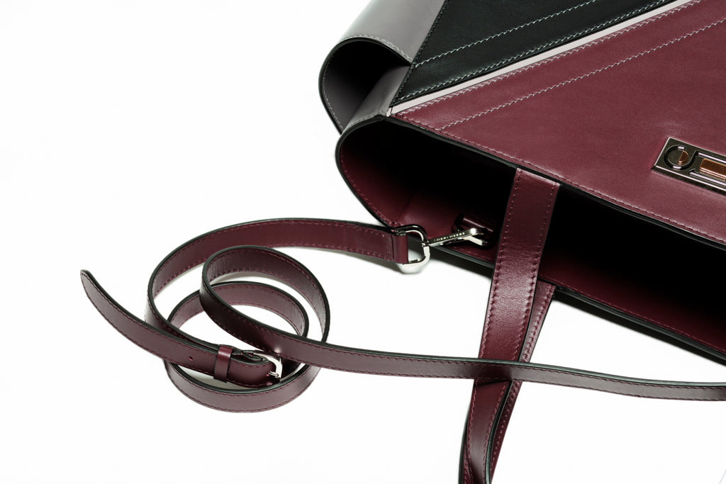 The Long Strap by Studio Tondini attached to The Maja Tote Bag. Burgundy leather strap with visible buckle and metal hook, enhancing refined versatility.