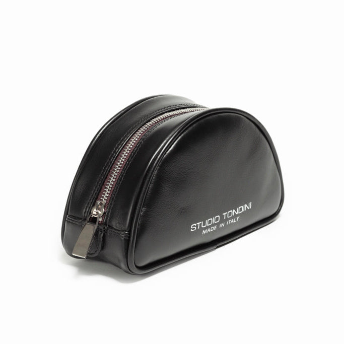 The Valentina Toiletry by Studio Tondini. Three-quarter view of black Italian leather pouch, featuring the signature burgundy zip detail unique to the Valentina line.