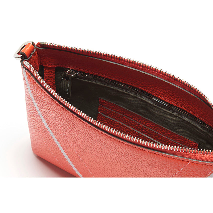 Interior detail of The Arianna Monochrome Pouch in Coral pebbled leather highlighting organised compartments and refined contemporary functionality.