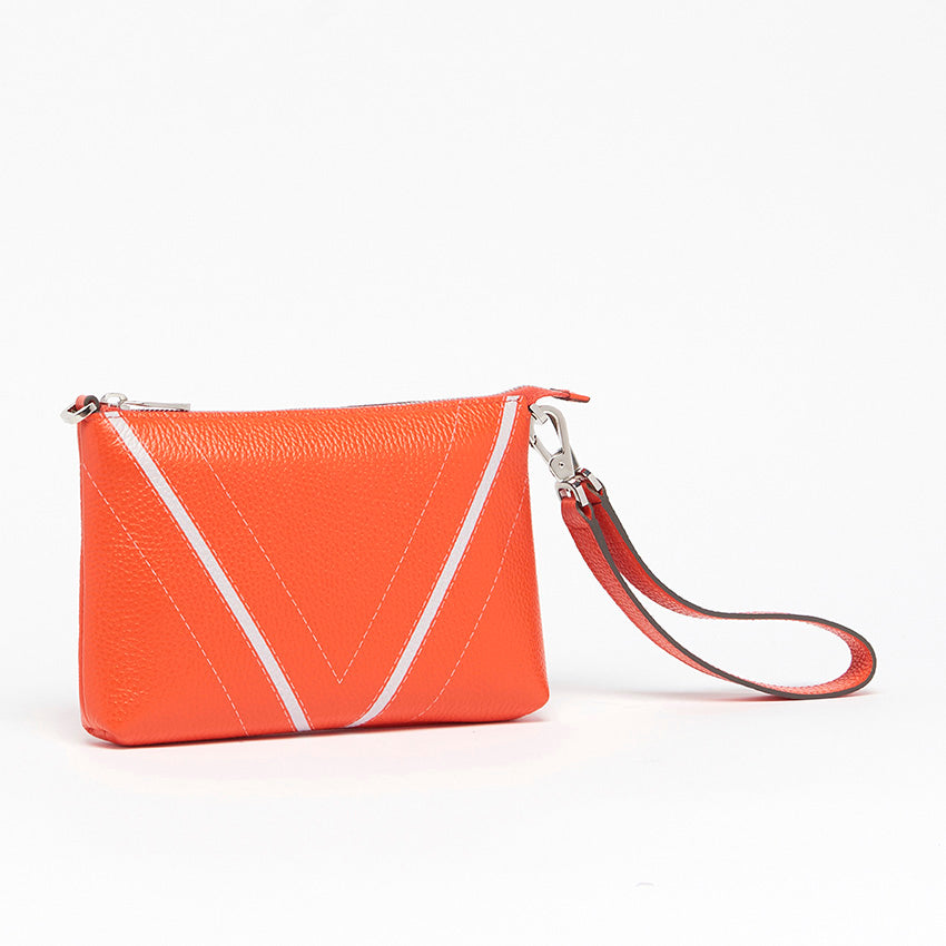 Three-quarter view of The Arianna Monochrome Pouch in Coral grained leather highlighting sculptural proportions and versatile contemporary elegance.