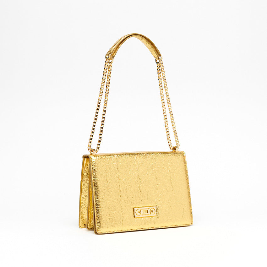 Three-quarter view of The Cristiana Vegan Shoulder Bag in gold Piñatex highlighting composed structure, 24K gold-plated hardware, and contemporary Italian craftsmanship.