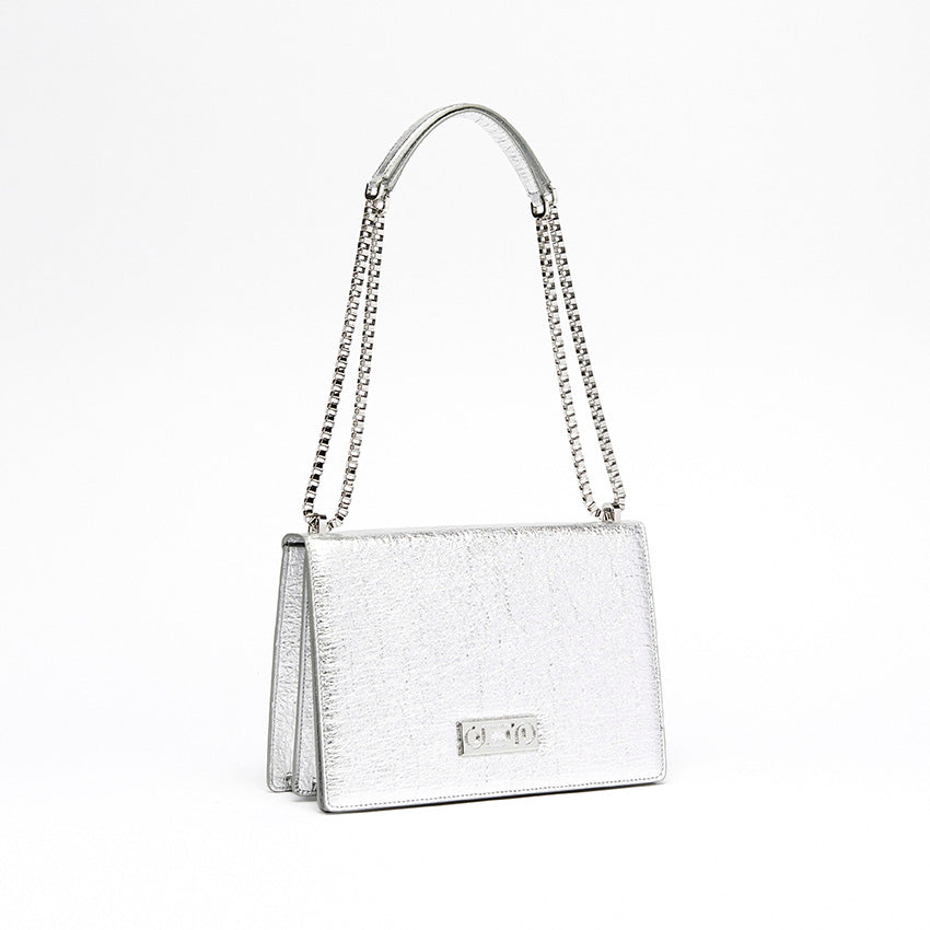 Three-quarter view of The Cristiana Vegan Shoulder Bag in silver Piñatex highlighting tactile materials, polished chain strap, and refined minimalist construction.