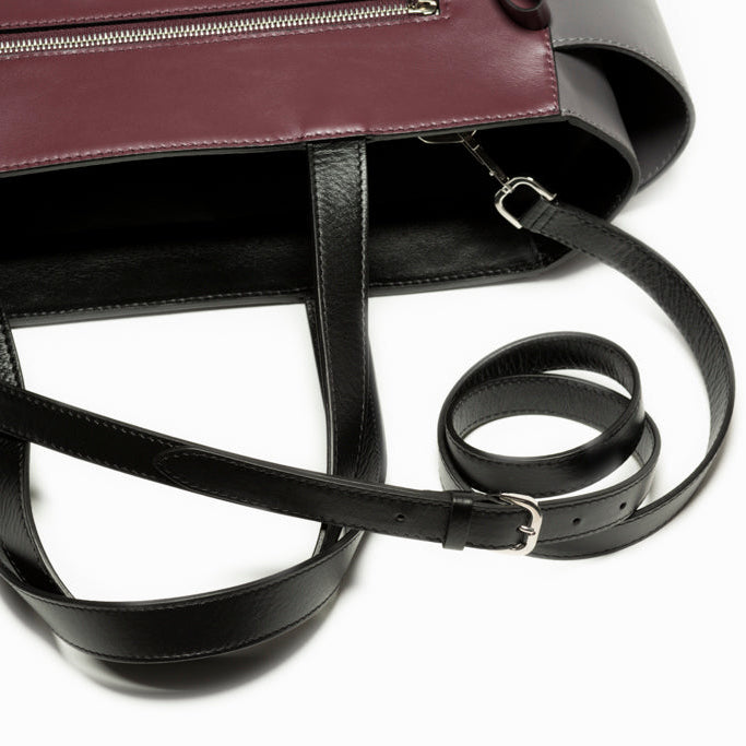 Close-up of The Long Strap in black leather highlighting adjustable functionality, refined Italian craftsmanship, and polished palladium-plated hardware.