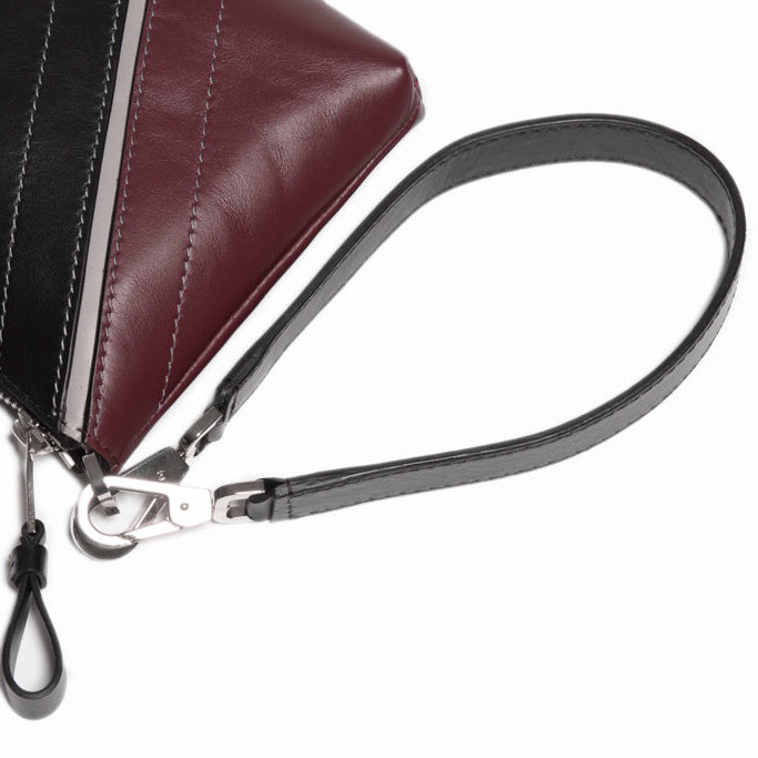 Close-up detail of The Arianna Pouch wrist strap and zip construction, highlighting refined leather craftsmanship and polished hardware.