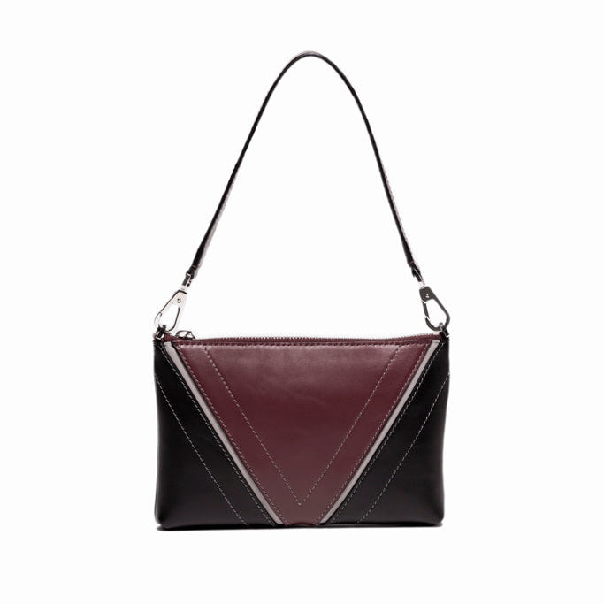 Front view of The Arianna Pouch featuring Studio Tondini’s signature V-shape construction, creating a bordeaux leather triangle on smooth black leather.