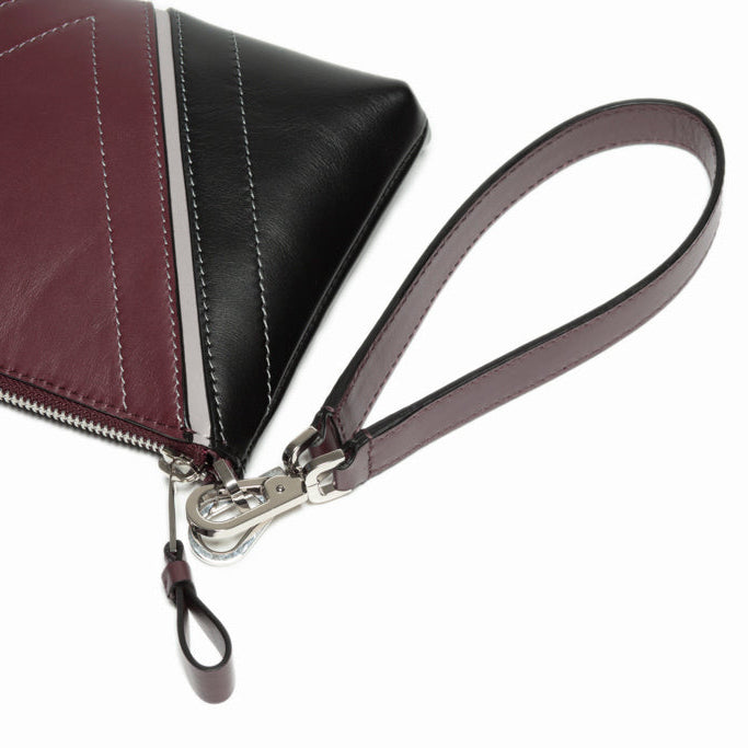 Close-up detail of The Arianna Pouch wrist strap and zip construction, highlighting refined leather craftsmanship and polished hardware.