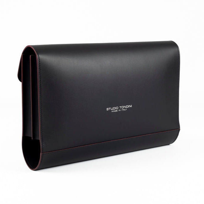 Three-quarter view of The Document Holder in smooth black leather with bordeaux edge detailing, showcasing slim construction and understated elegance.