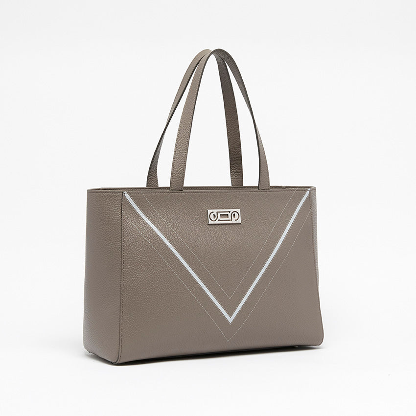 Three-quarter view of The Maja Monochrome Tote Bag in taupe pebbled leather, showcasing sculptural construction and contemporary Italian craftsmanship.