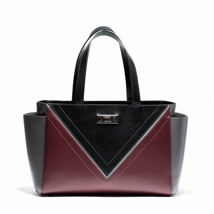 Front view of The Maja Tote Bag featuring Studio Tondini’s signature V-shape construction, creating a black leather triangle on smooth bordeaux leather.