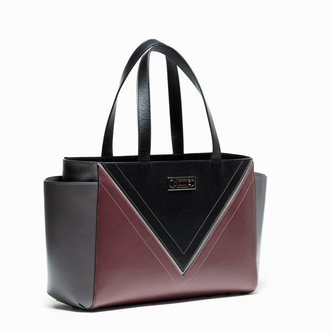 Three-quarter view of The Maja Tote Bag with Studio Tondini’s signature V-shape construction creating a black leather triangle, showcasing architectural contemporary craftsmanship.