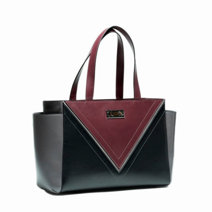 Three-quarter view of The Maja Tote Bag with Studio Tondini’s signature V-shape construction creating a bordeaux leather triangle, showcasing architectural contemporary craftsmanship.