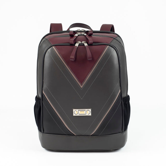 Front view of The Simona Backpack featuring Studio Tondini’s signature V-shape construction, creating a bordeaux leather triangle on smooth dark grey leather.