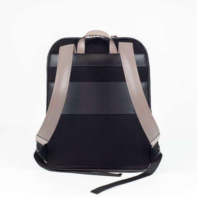 Back view of The Simona Backpack in smooth black leather with ergonomic shoulder straps in light grey leather and clean architectural construction.